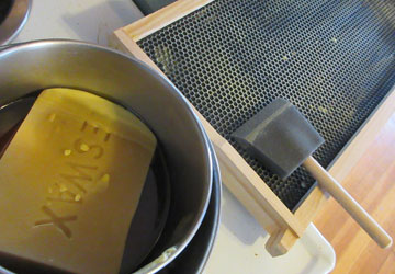 Image of: plastic foundation being painted with bees wax to encourage bees to draw comb